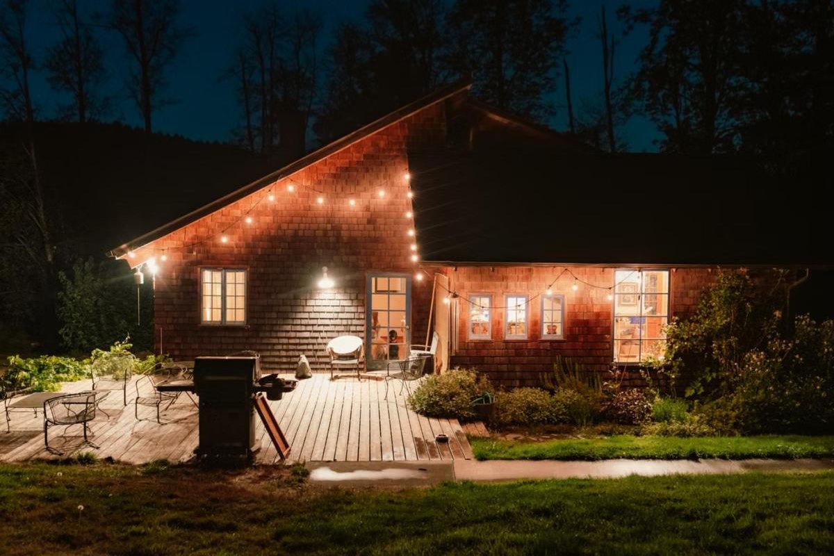 Casa con terraza de madera iluminada con guirnaldas de luces cálidas